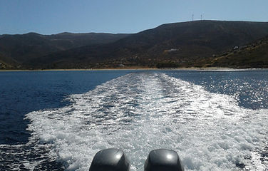 A RIB motorboat sailing away from the Island of Sifnos on an Island sea transfer to another Island.