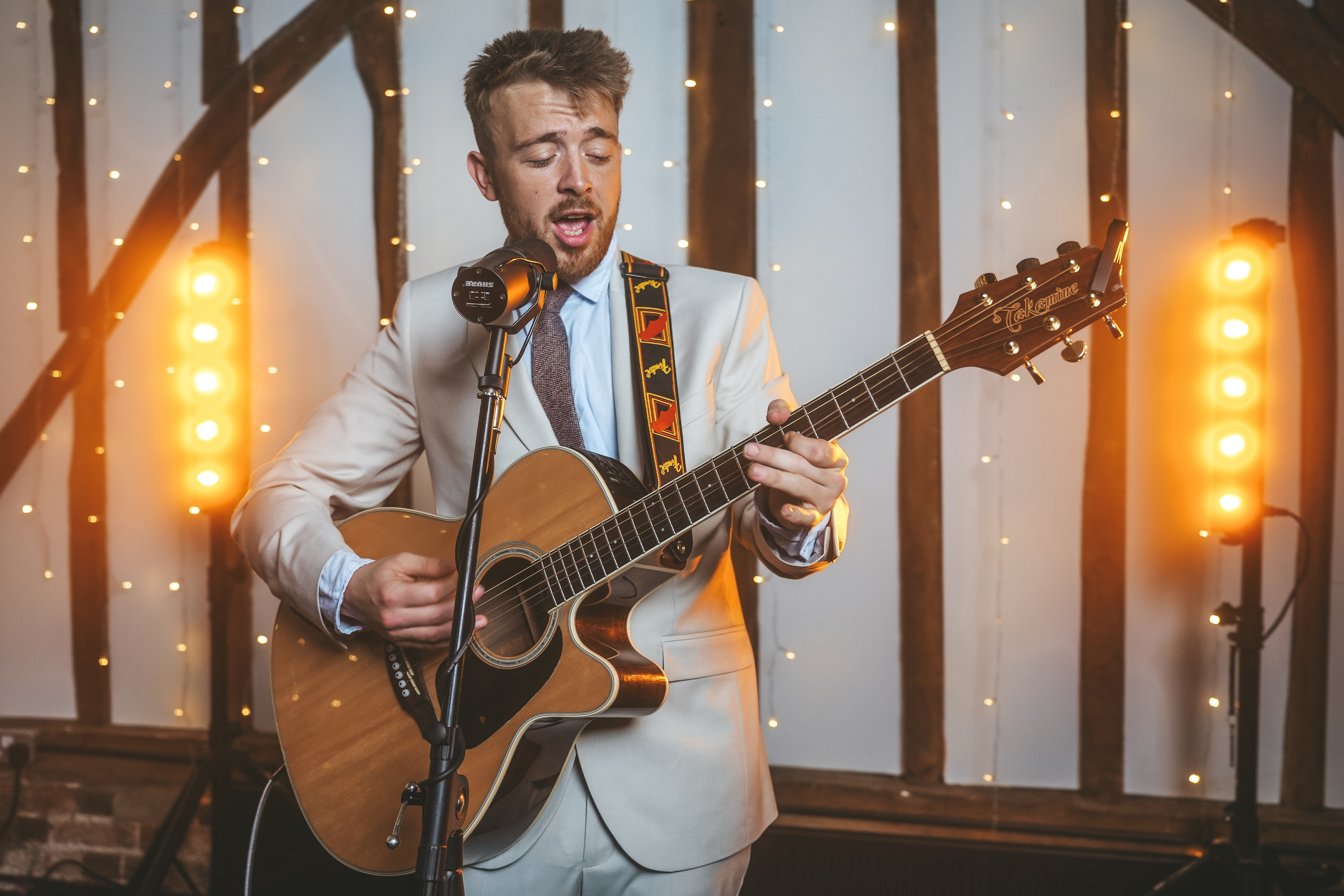 Callum Richards performing live with acoustic guitar at an elegant event