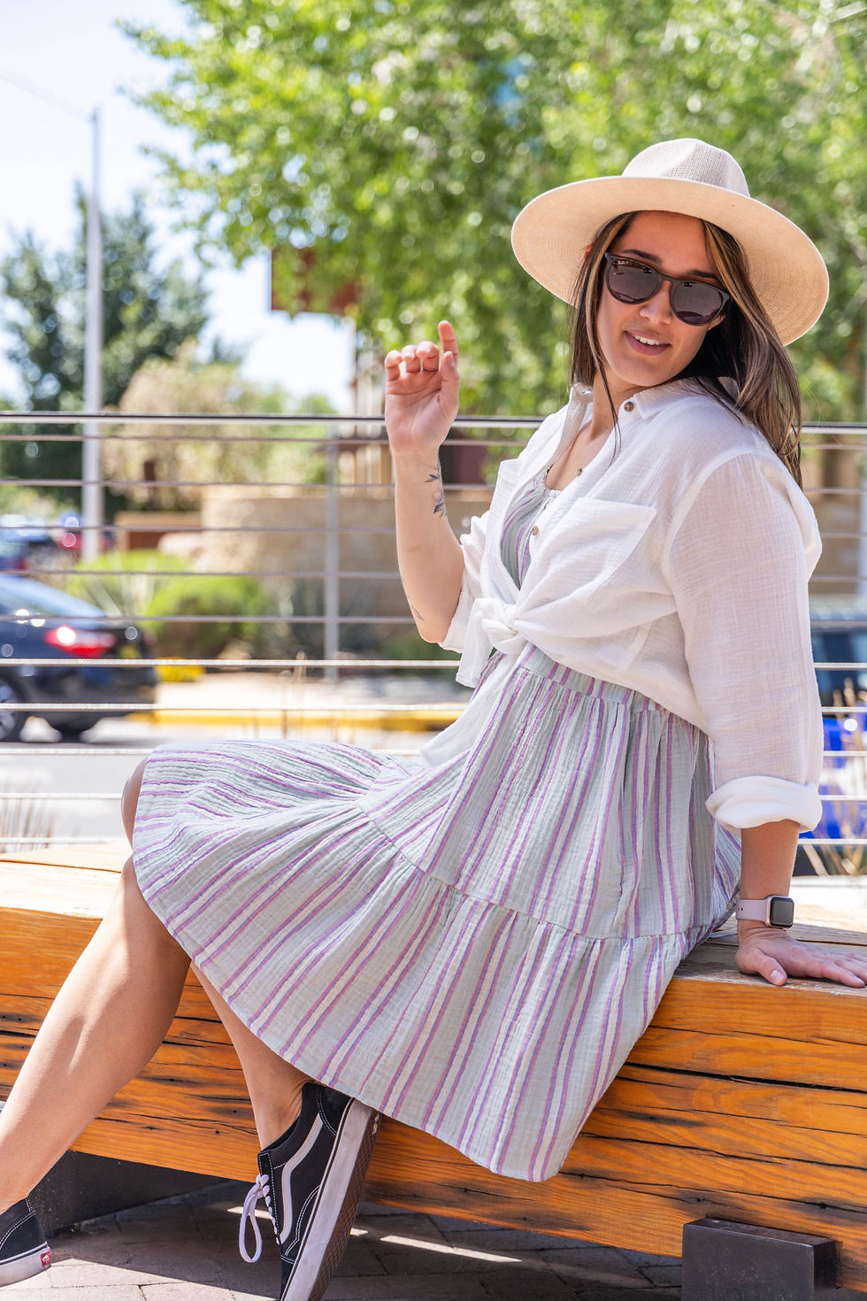 A girl posing and wearing a sundress and sunhat.