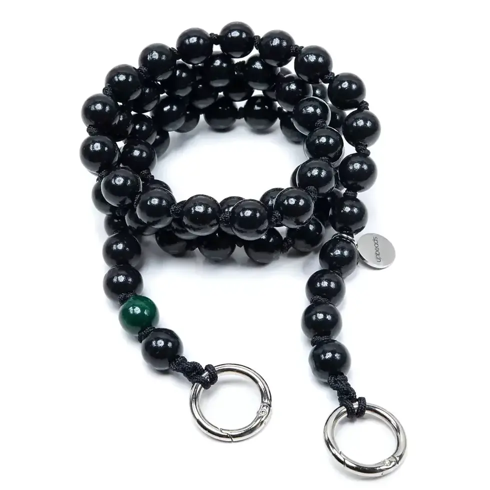Black beaded bracelet with silver rings and green accent