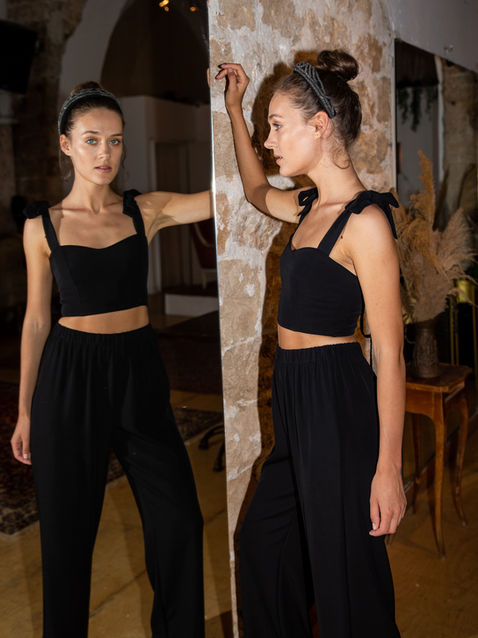 Model in black crop top and pants