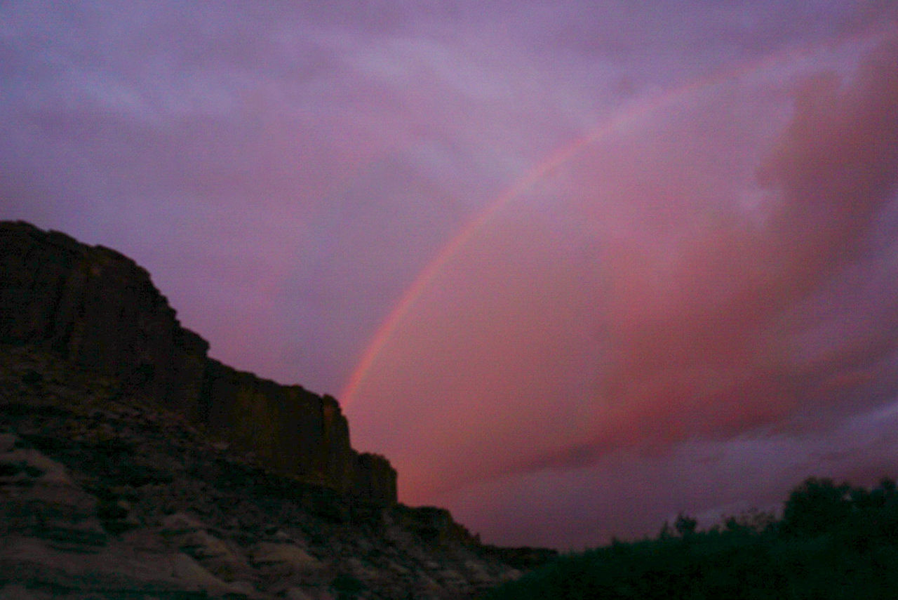 a rainbow against a pink sky over our campsite