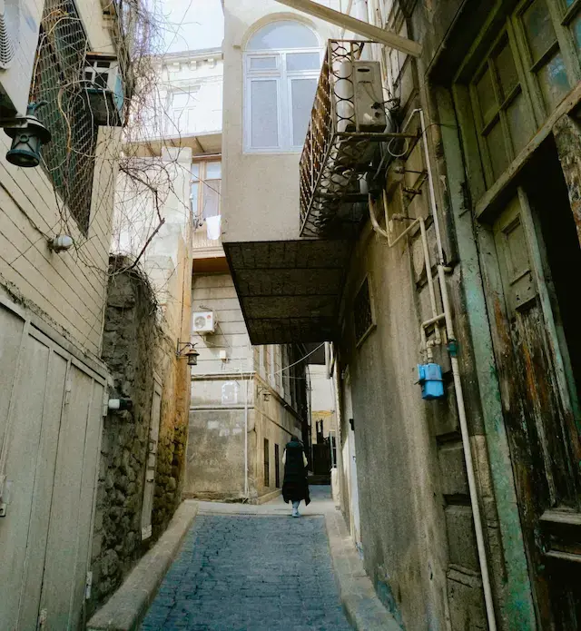 Photo by Orkhan Aliyev of Pexels of a small side street with green door in Damascus Old Town just like where I lived.