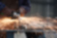 worker in factory grinding metal.jpg