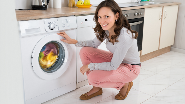 Woman washing quilt in washing machine