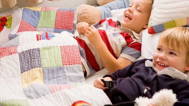 Children laughing and enjoying patchwork quilt