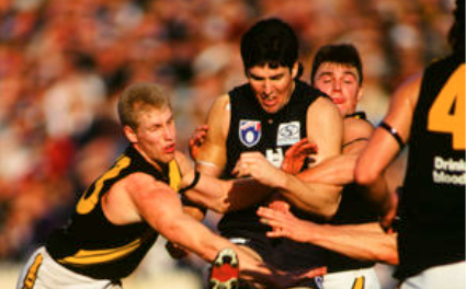 Carlton captain Stephen Kernahan gets a kick away against the Tigers