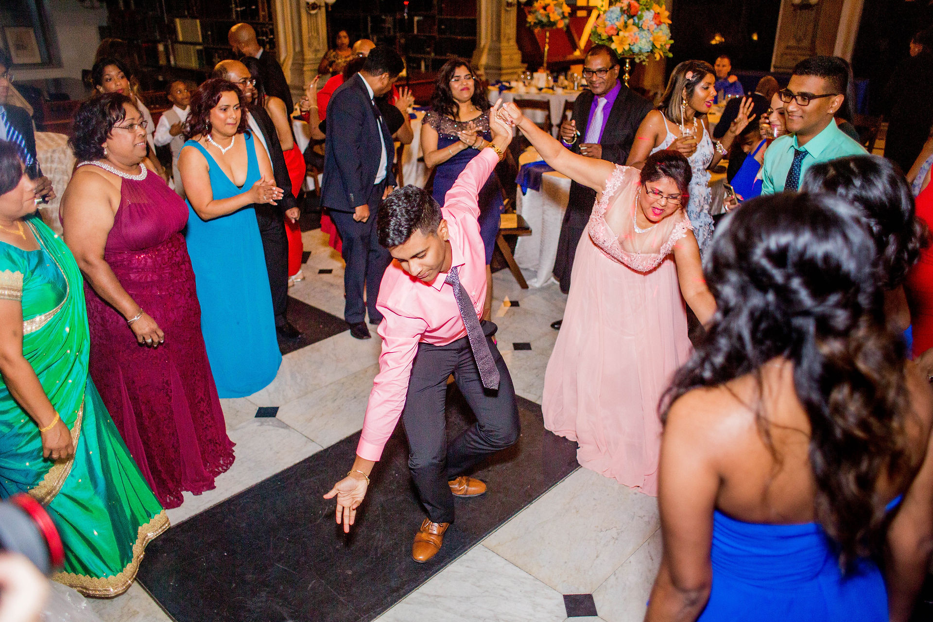 guy in pink shirt dancing surrounded by guests