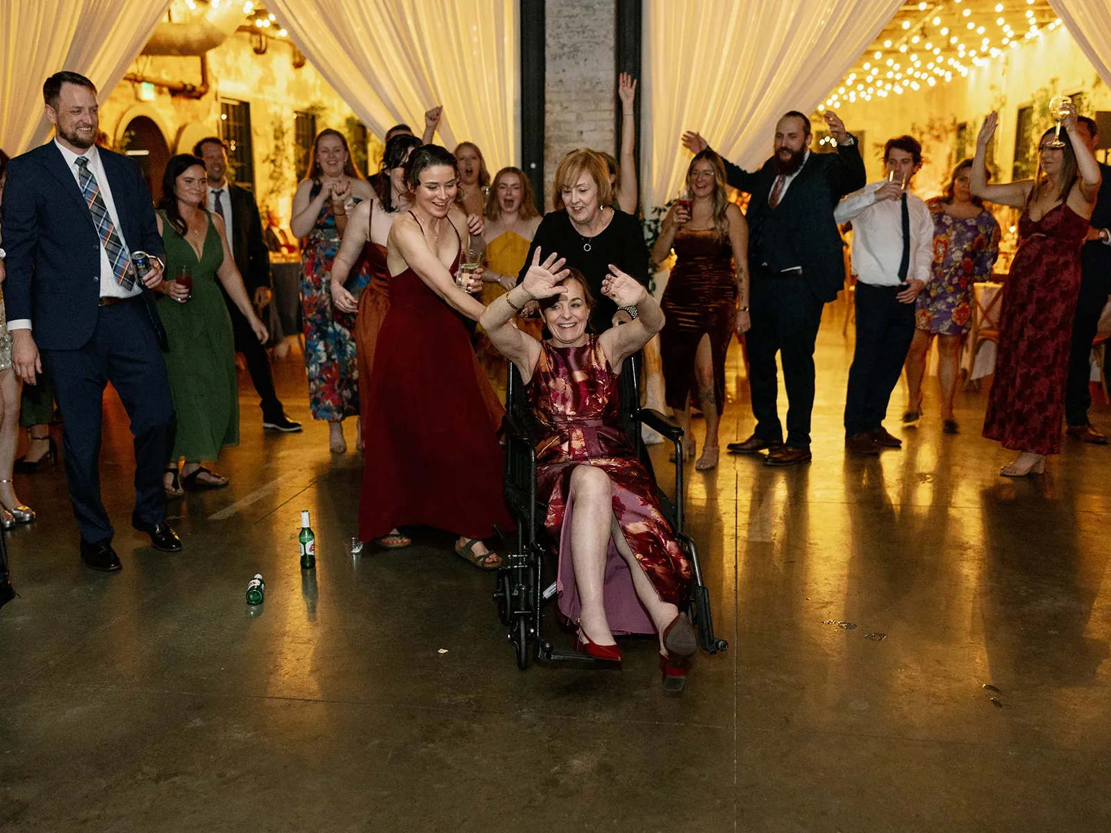woman in red dress in wheelchair dancing with hands up