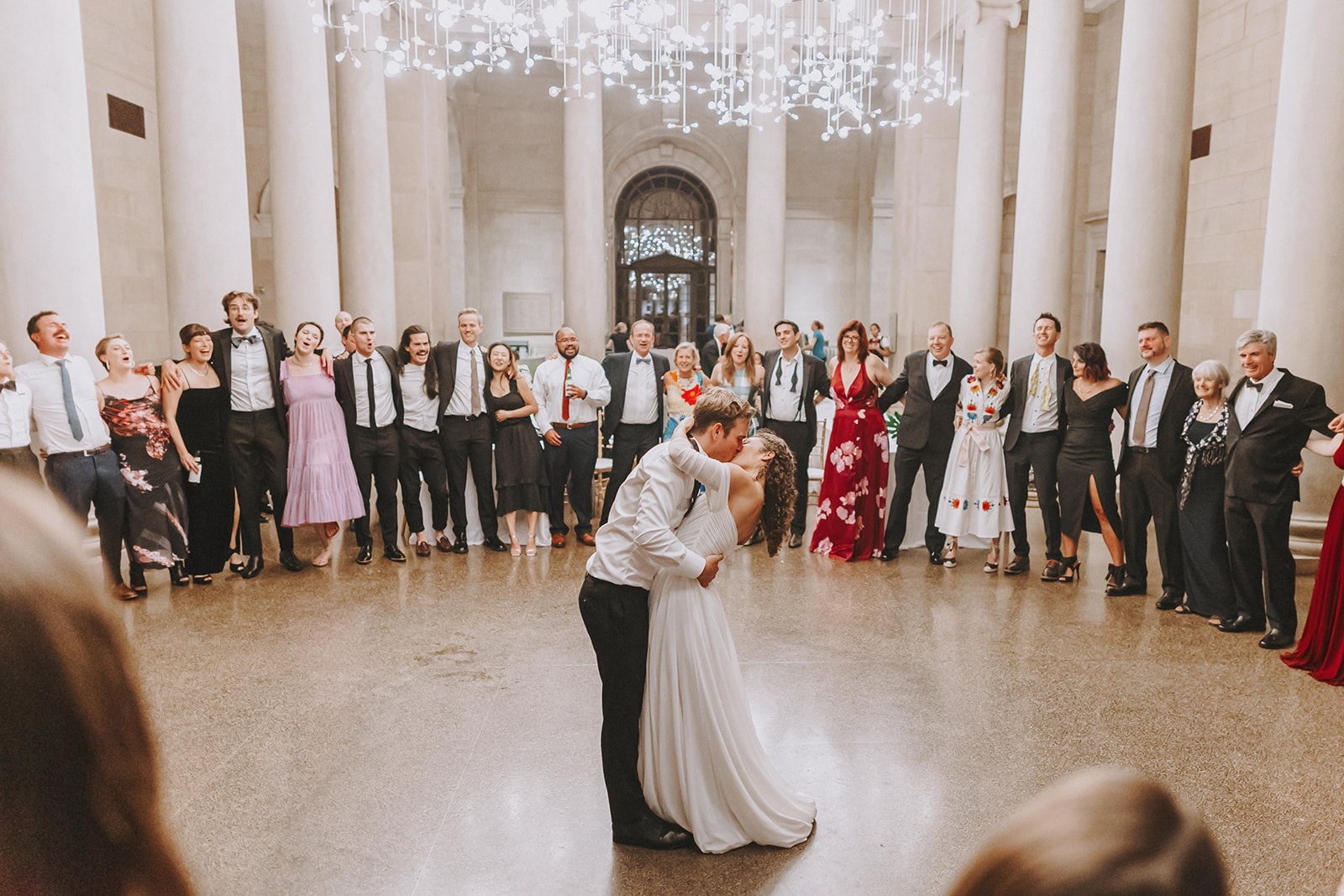 bride and groom kiss during last dance while guests surround them in a circle