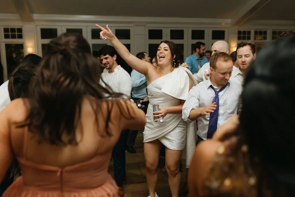 bride dancing with hand up at wedding