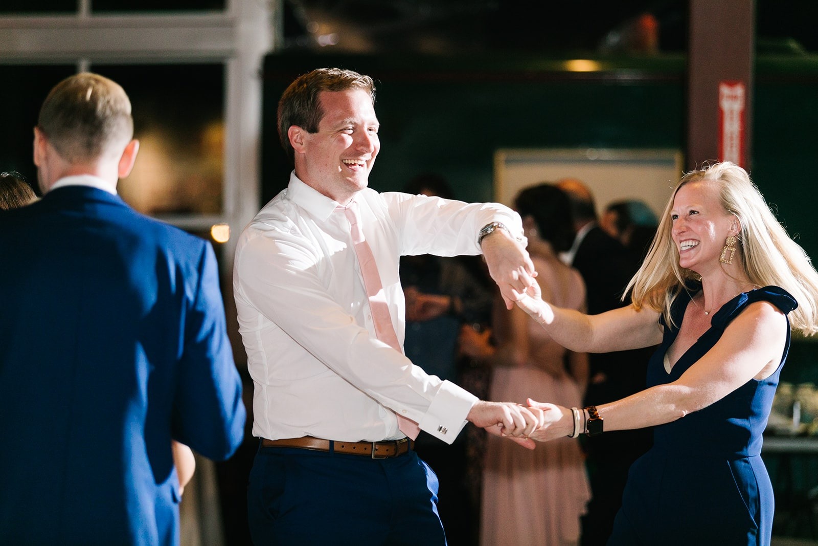 guy spinning smiling woman at wedding