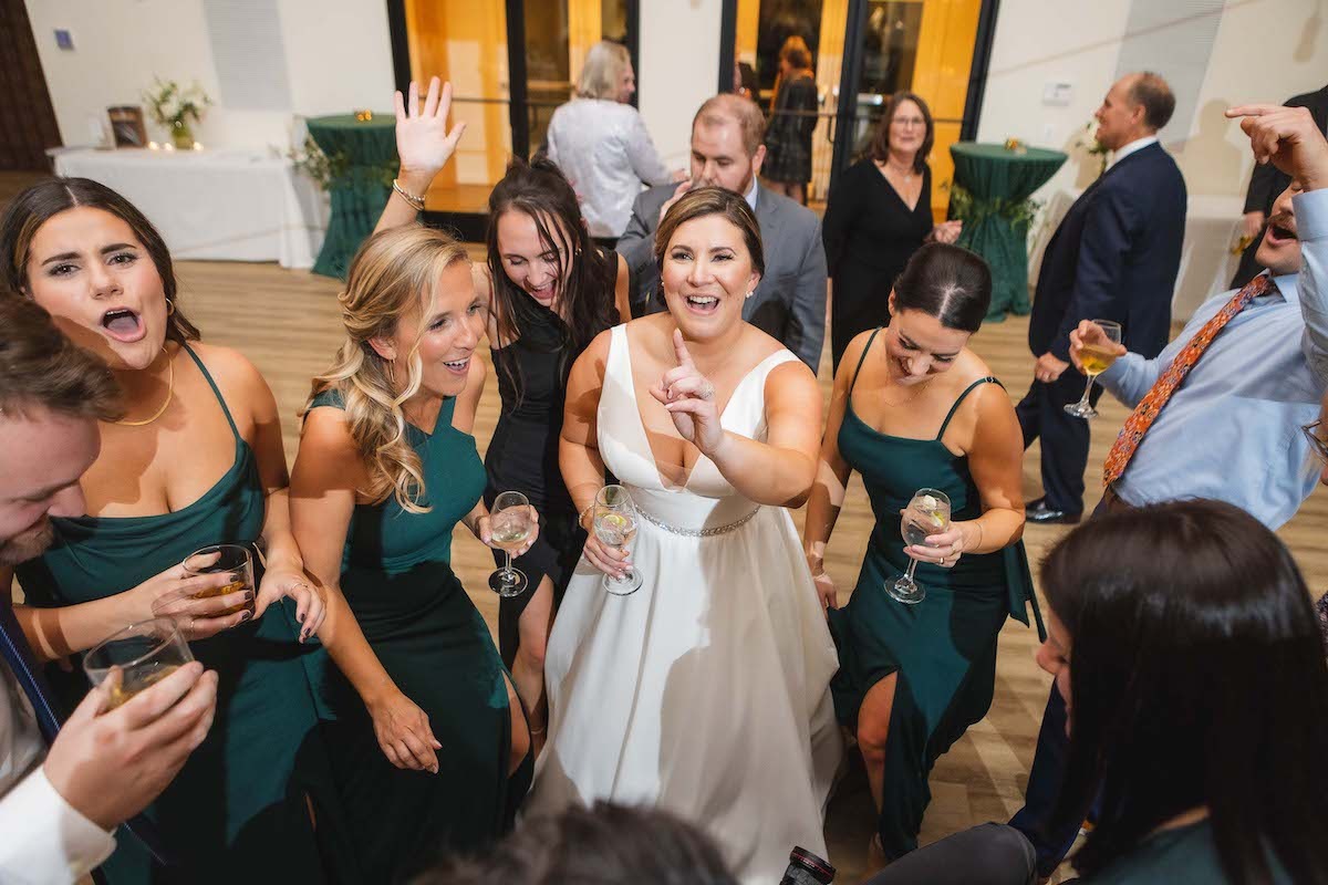bride and women in green dresses dancing at wedding