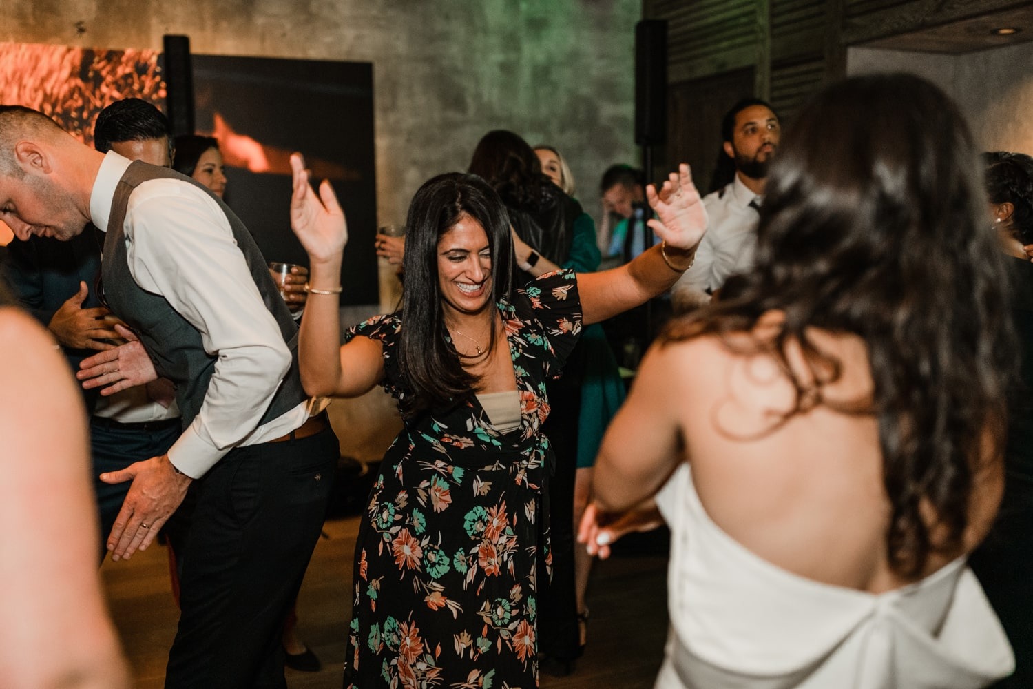woman in floral dress dancing with hands up