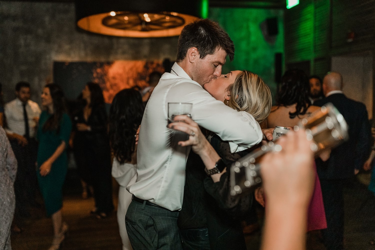 young couple kissing on dance floor of wedding