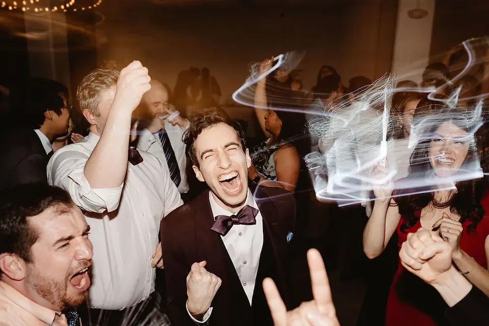 guys partying at wedding and smiling