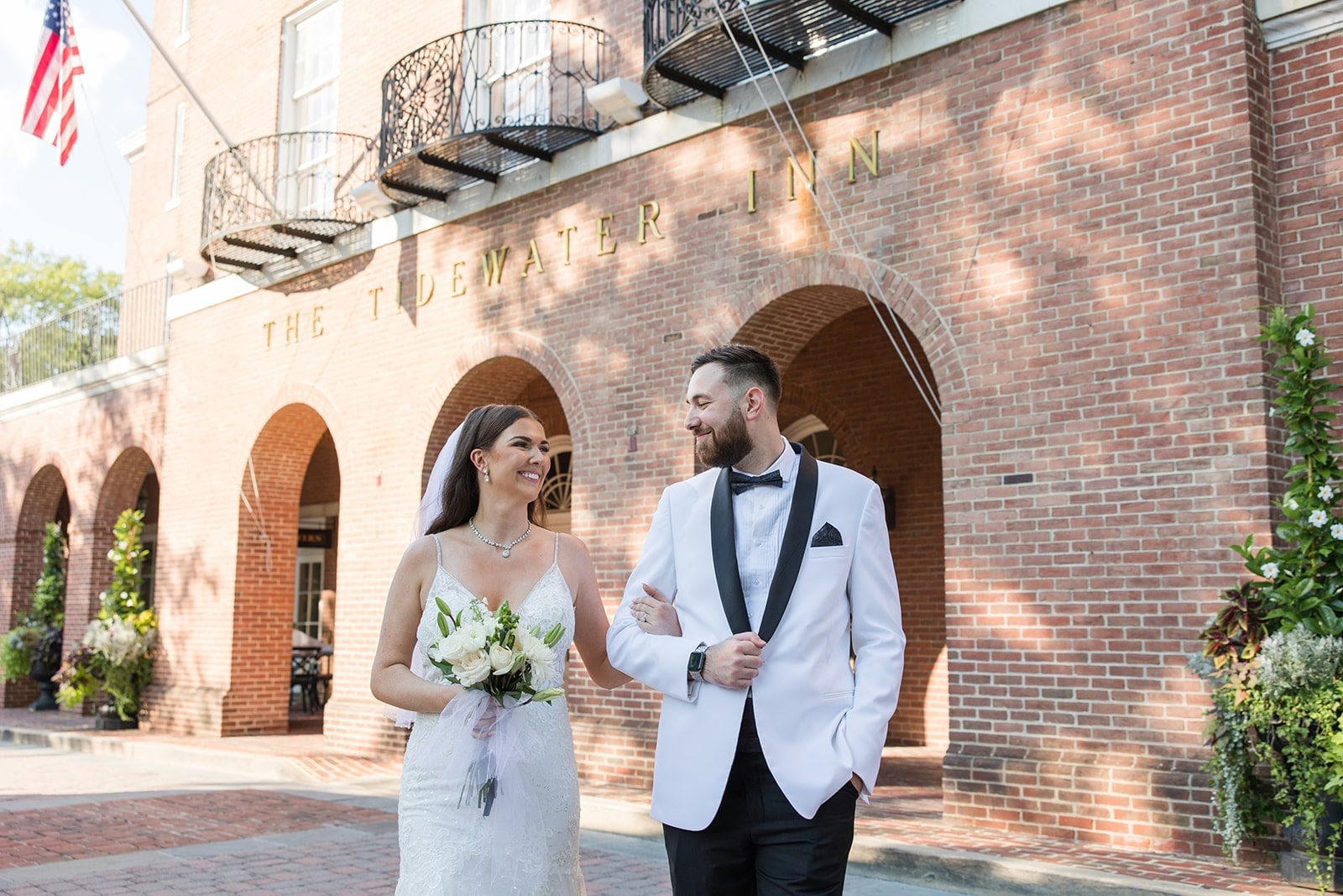 bride and groom posing in front of tide water inn