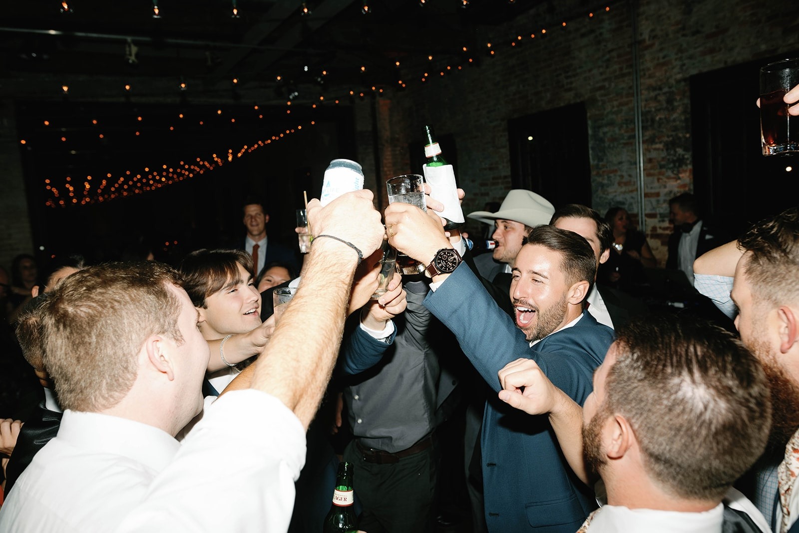 groom and guys cheers beer while dancing