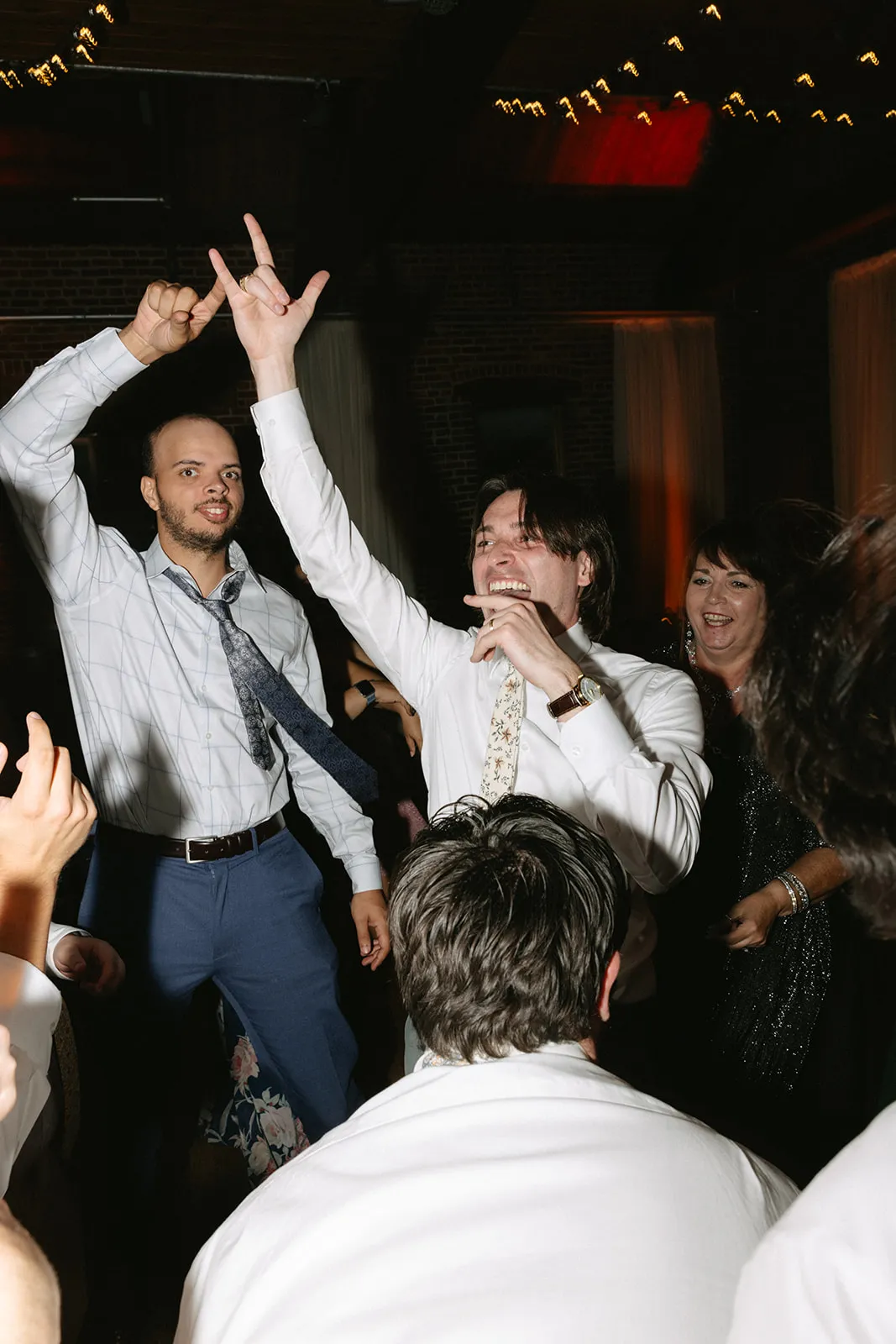 guys dancing with hands up at wedding