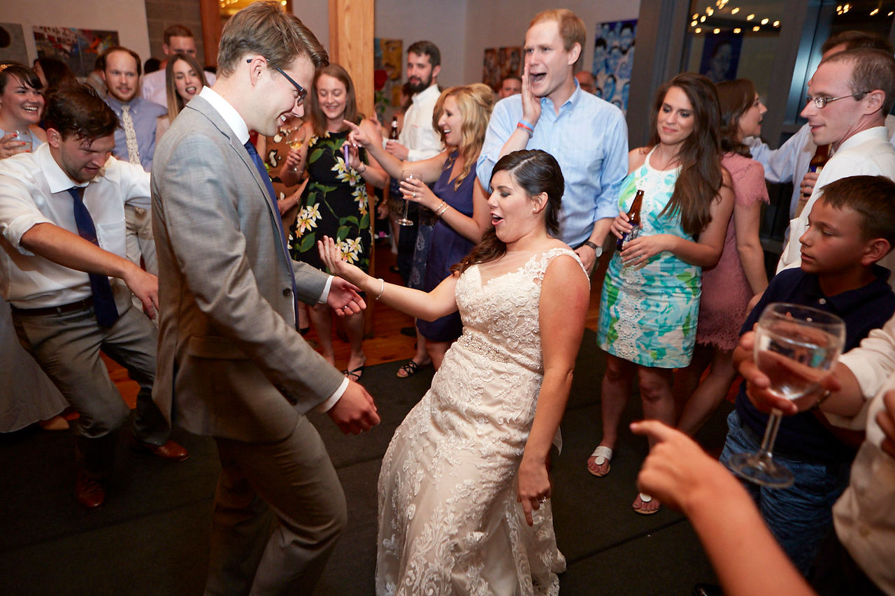 bride and groom dance surrounded by friends