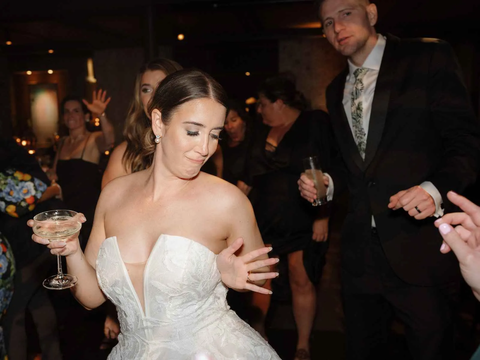 bride dancing while holding glass of champagne