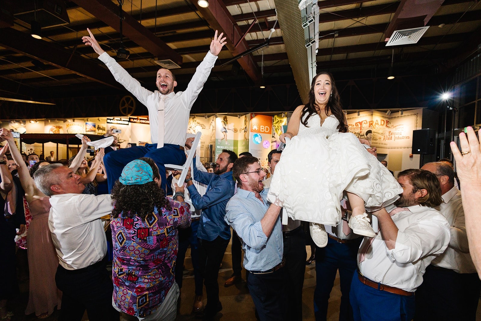 bride and groom raised up on chairs for hora