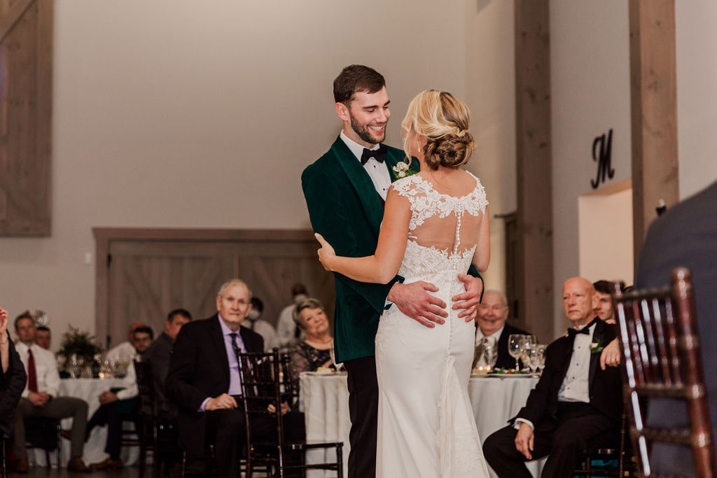 bride and groom slow dance while guests watch