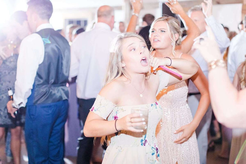 young blonde woman dancing with drink in hand