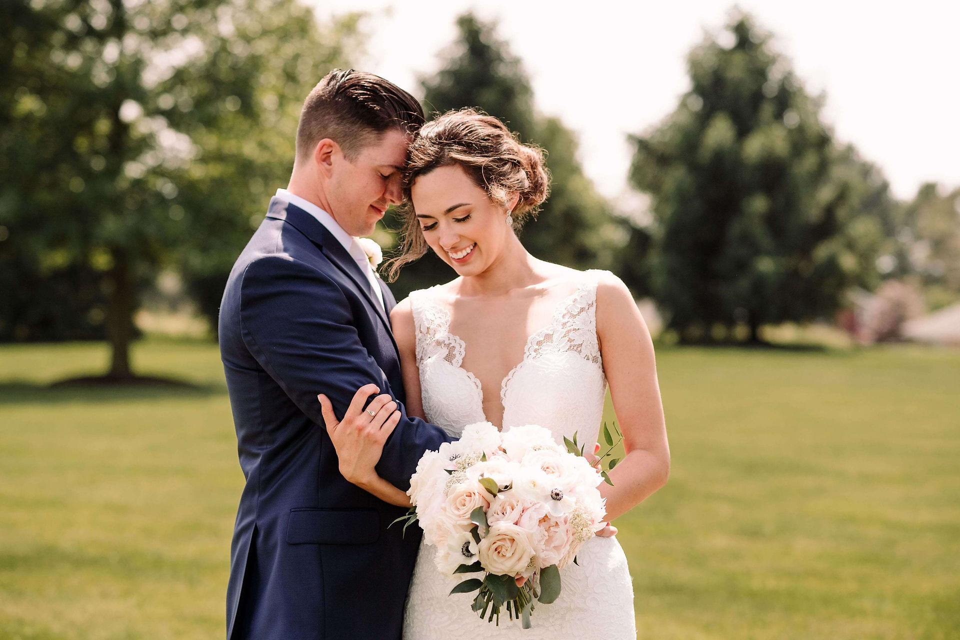 bride and groom pose outside on grass