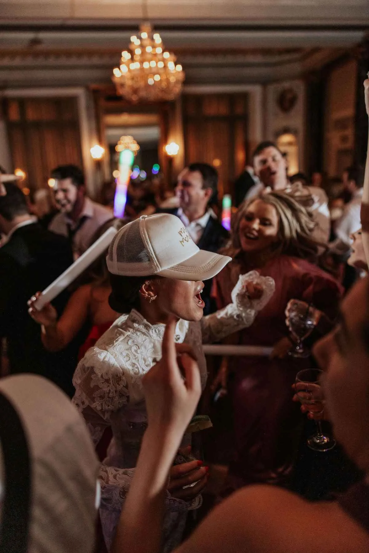 bride wearing a trucker hat dancing at wedding