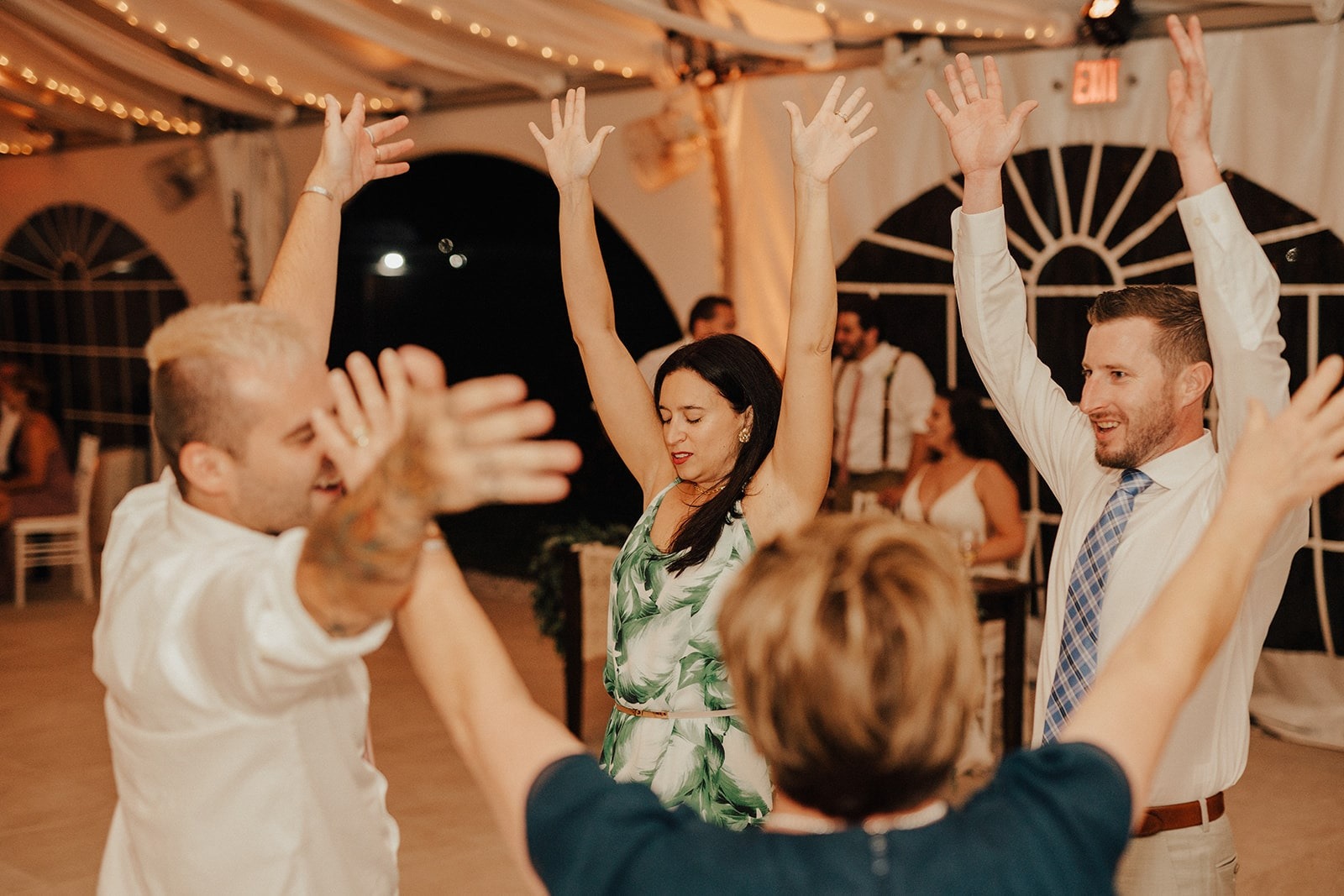 wedding guests dance with hands up