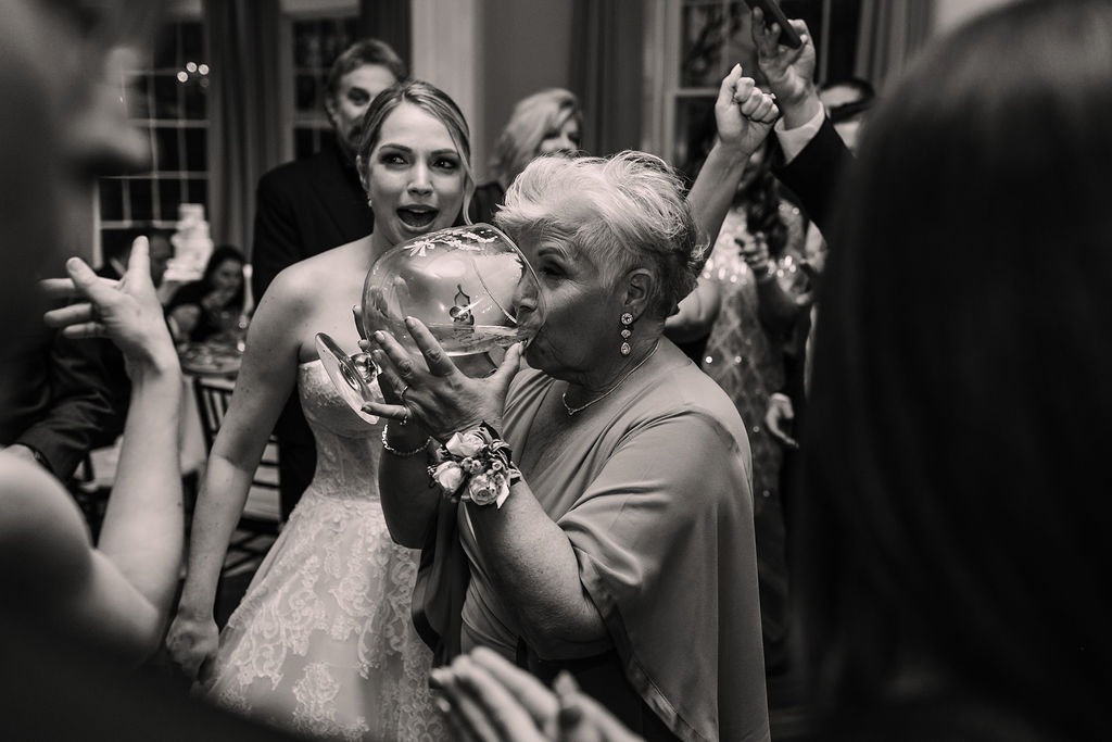 woman drinking out of a bowl-sized glass on dance floor