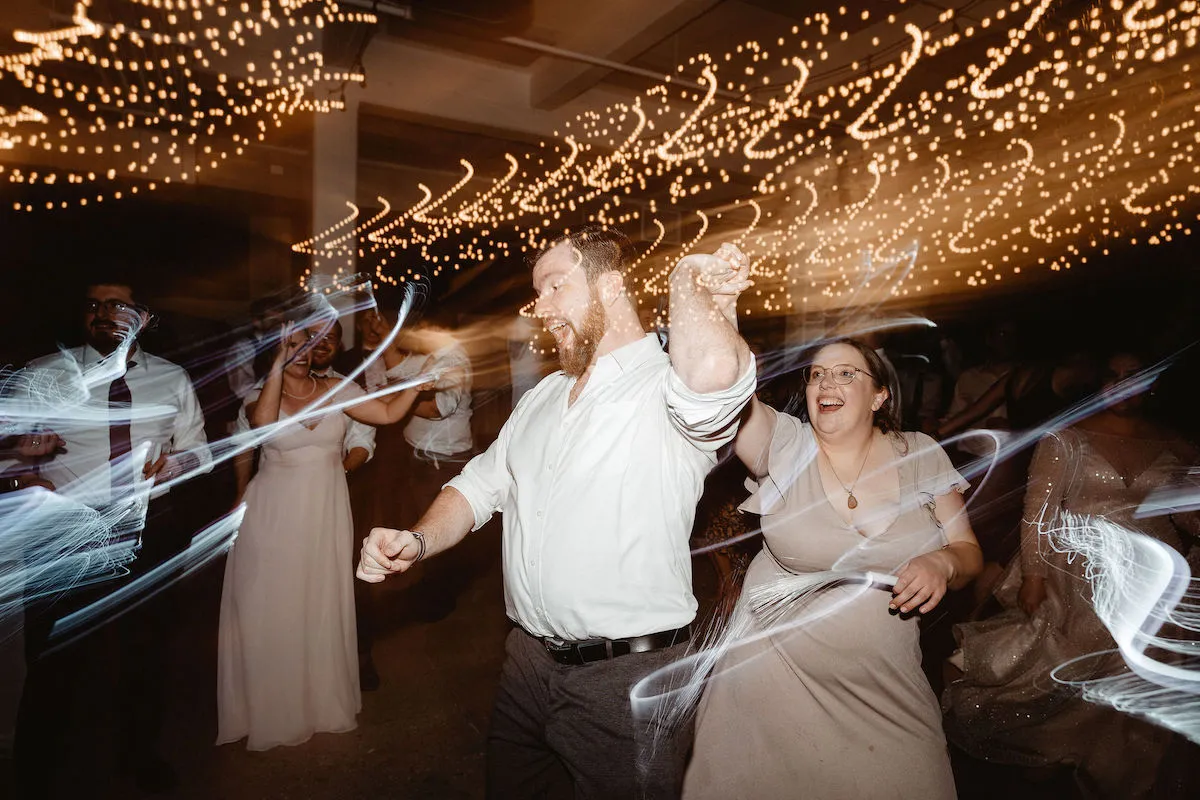 guy in white shirt dancing with bridesmaid in grey dress