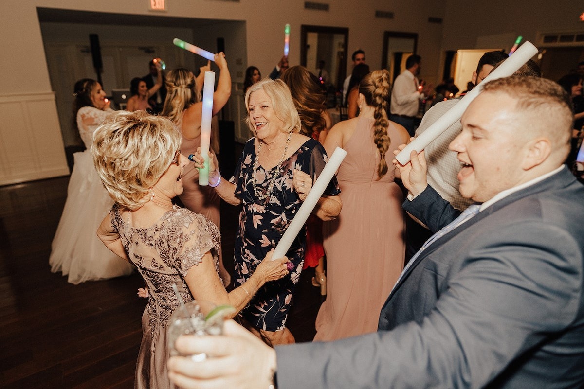 guests dance with light batons at wedding