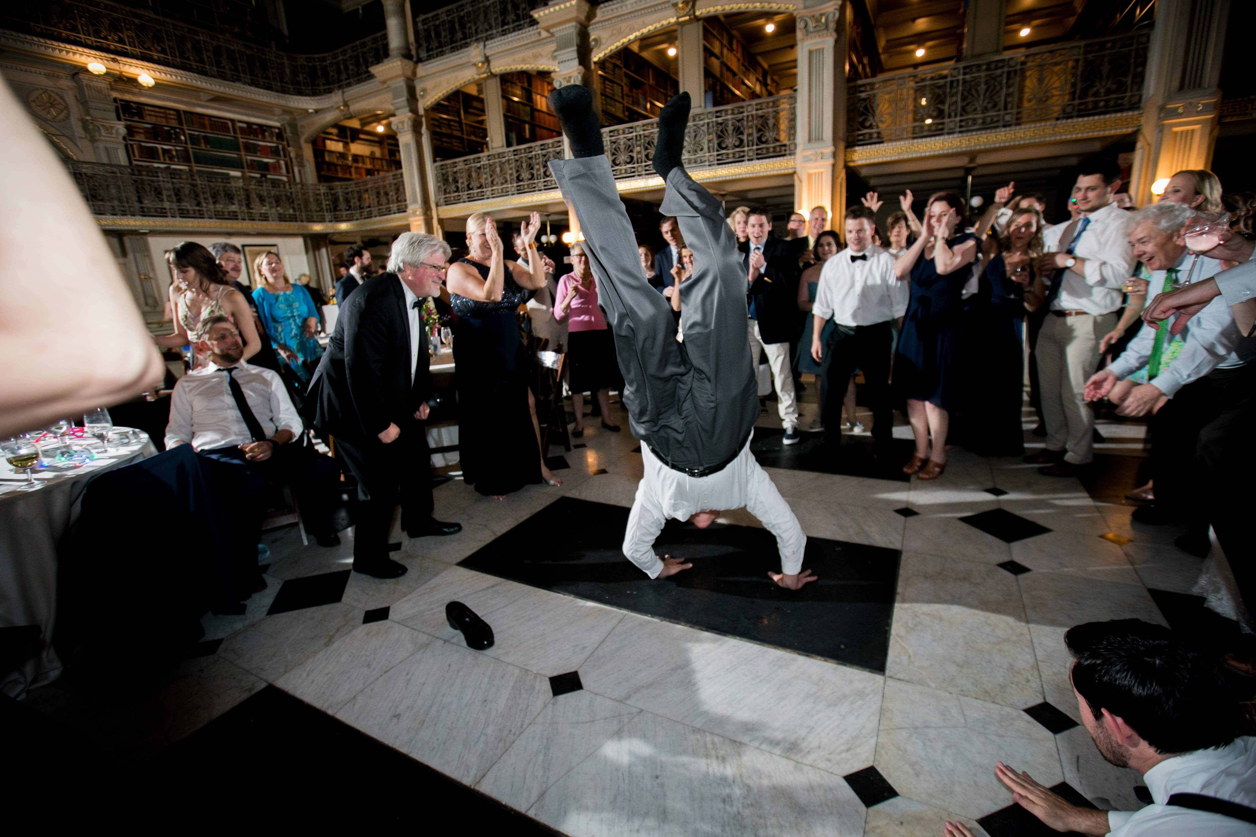 guy does the worm at at wedding while guests watch