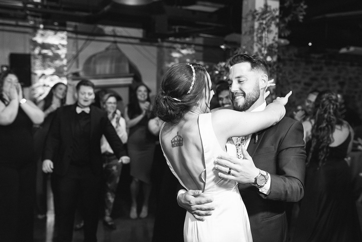 bride and groom first dance surrounded by wedding party