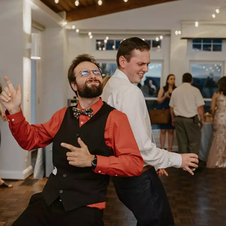 two men dancing back to back at wedding