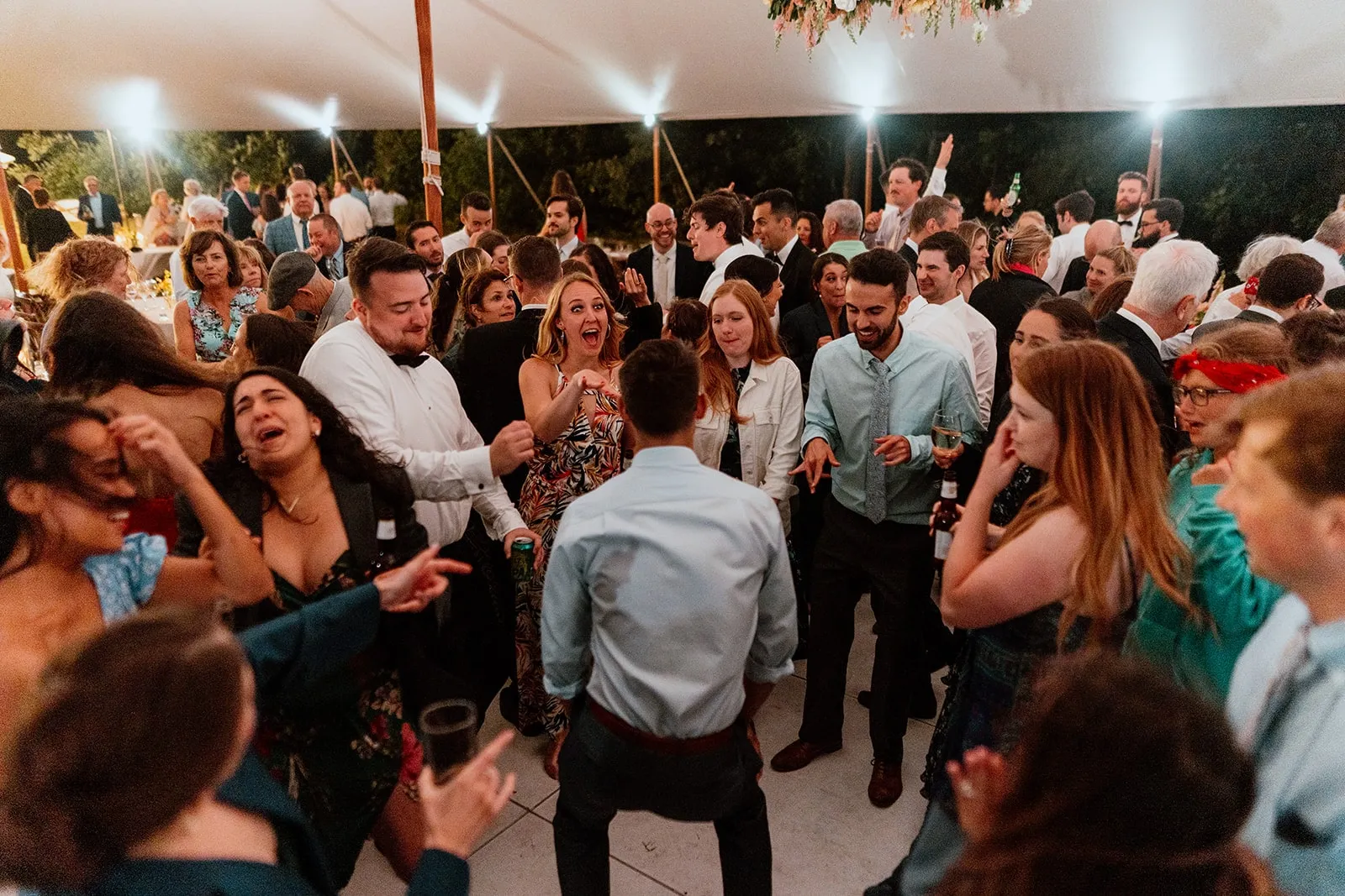 wedding guests dancing under tent