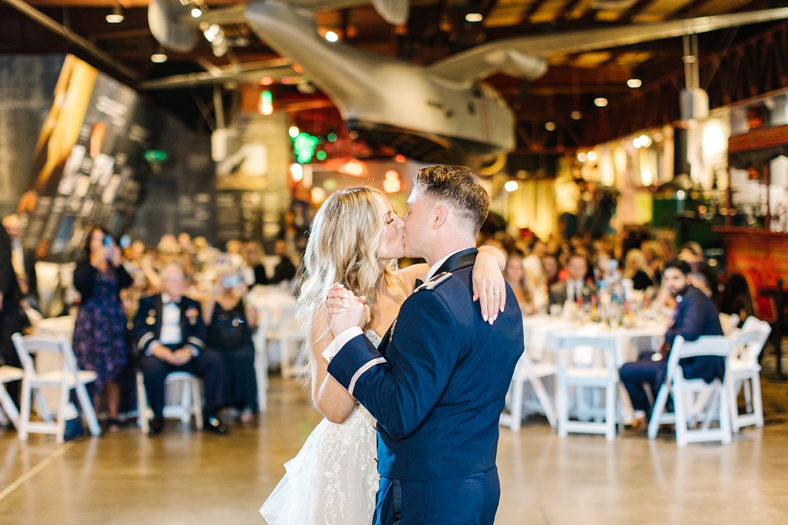 bride and groom kiss during first dance while guests watch from their seats