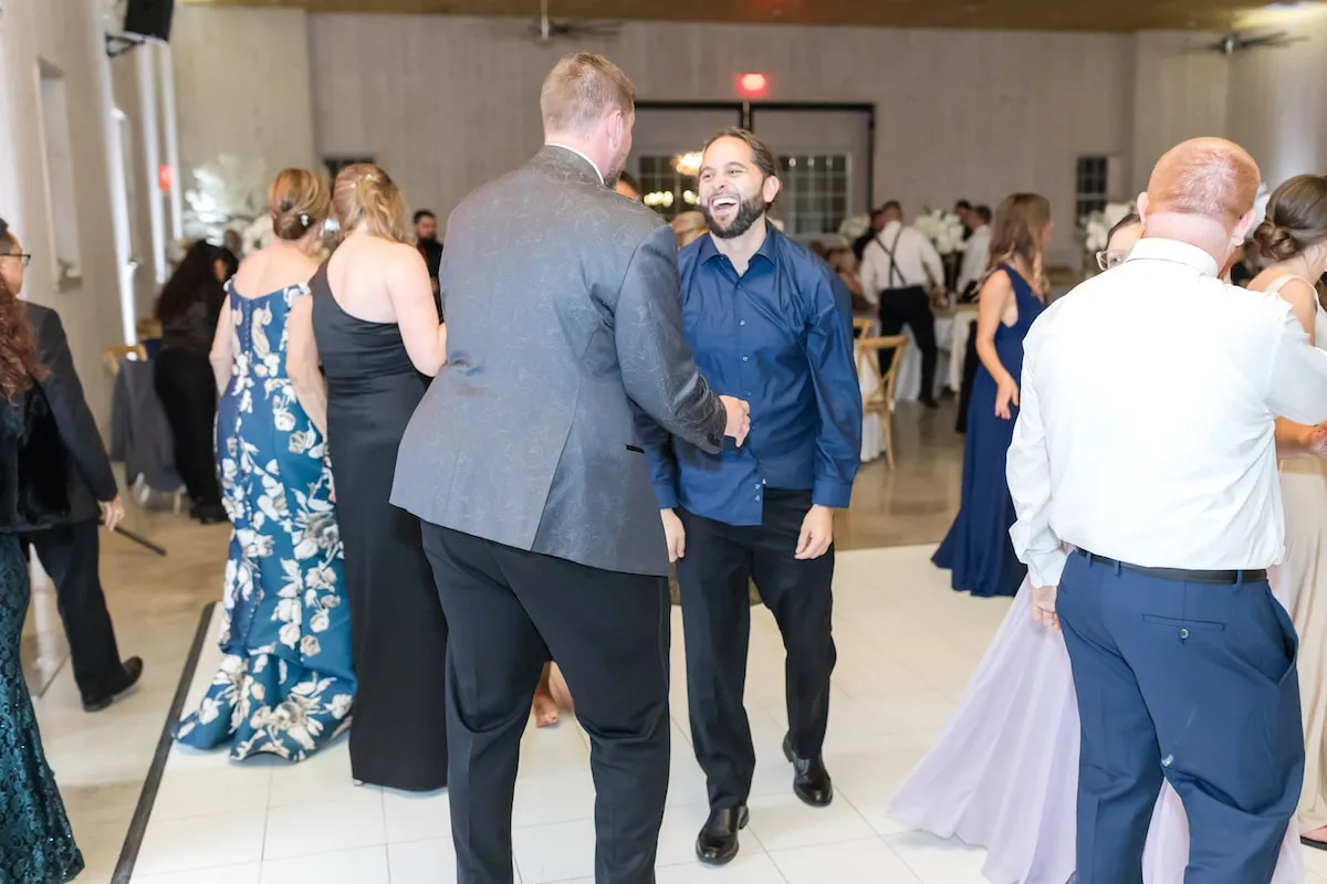 guy smiling and dancing with groom