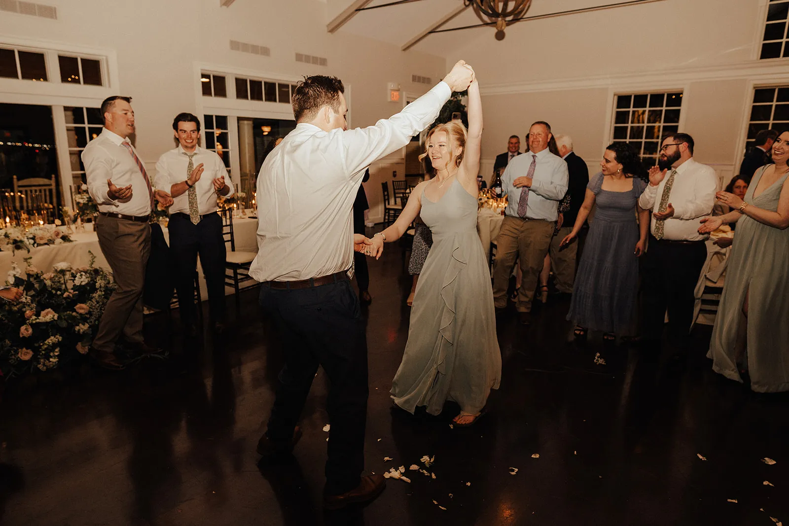 guy spinning bridesmaid while guests watch