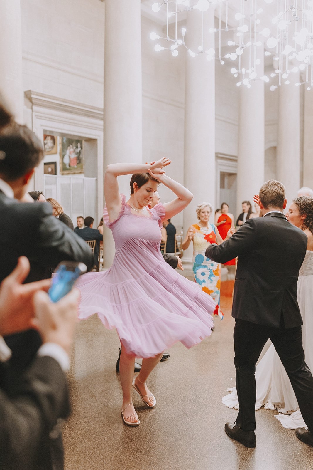 woman in light pink dress dancing and spinning at wedding