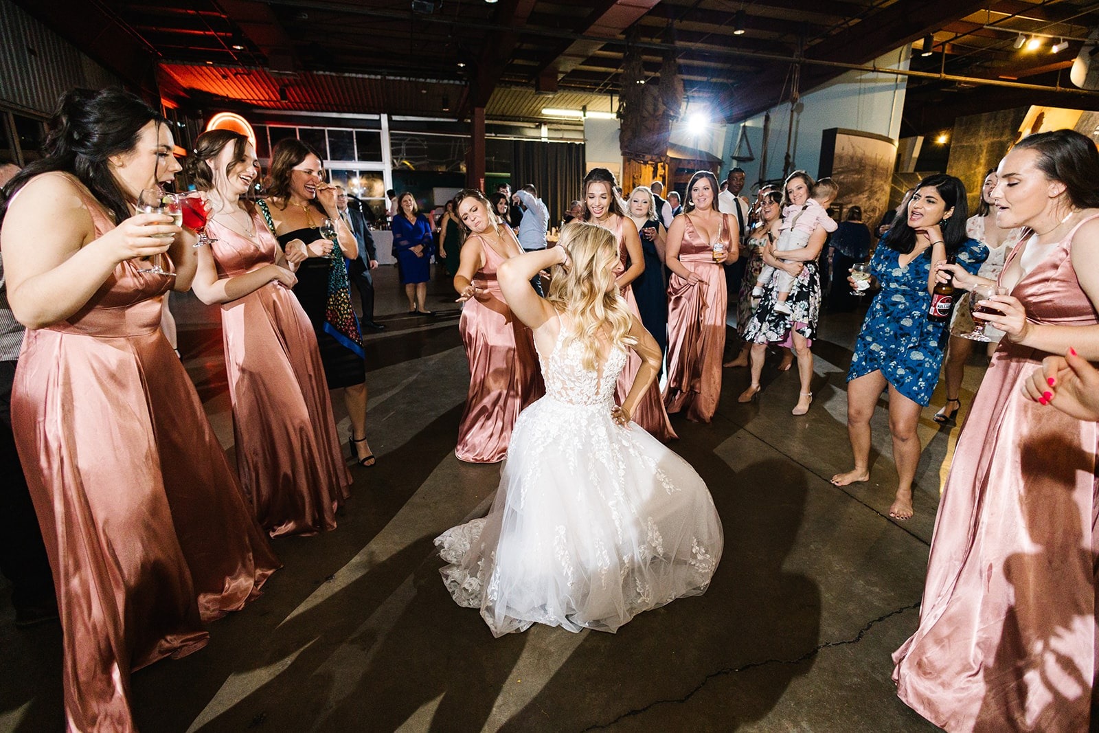 bride dancing in center of bridesmaids