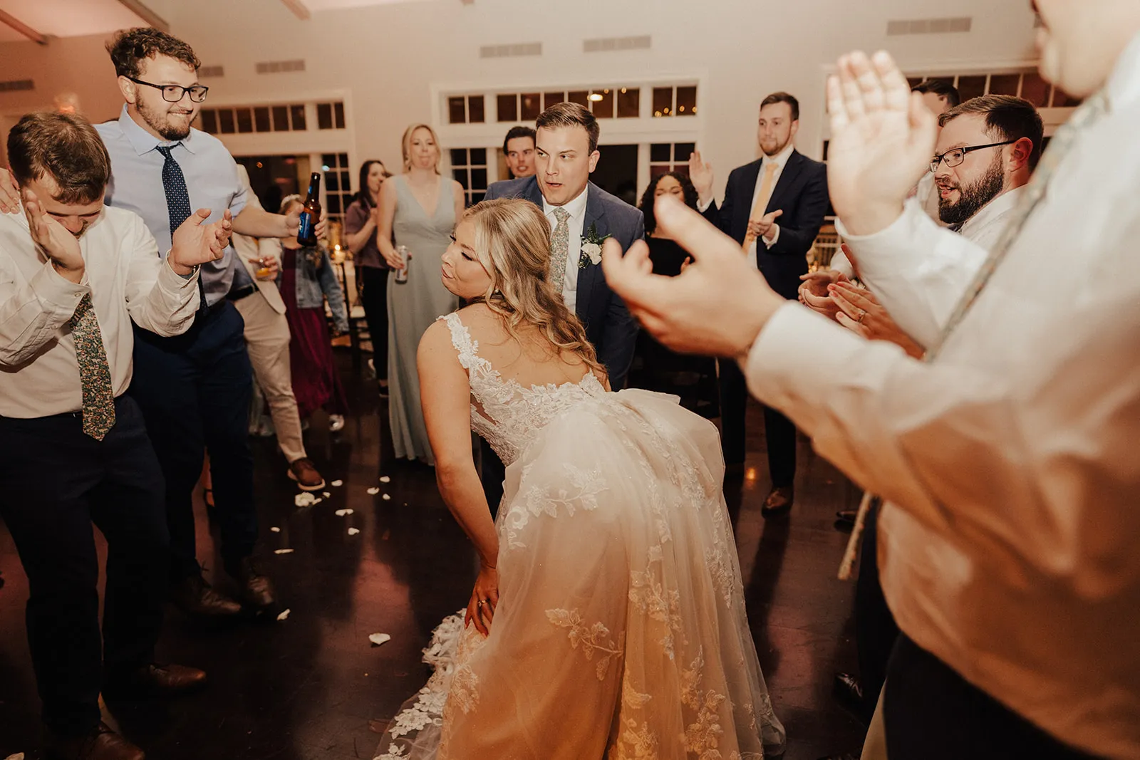 bride dancing bent over while guests clap