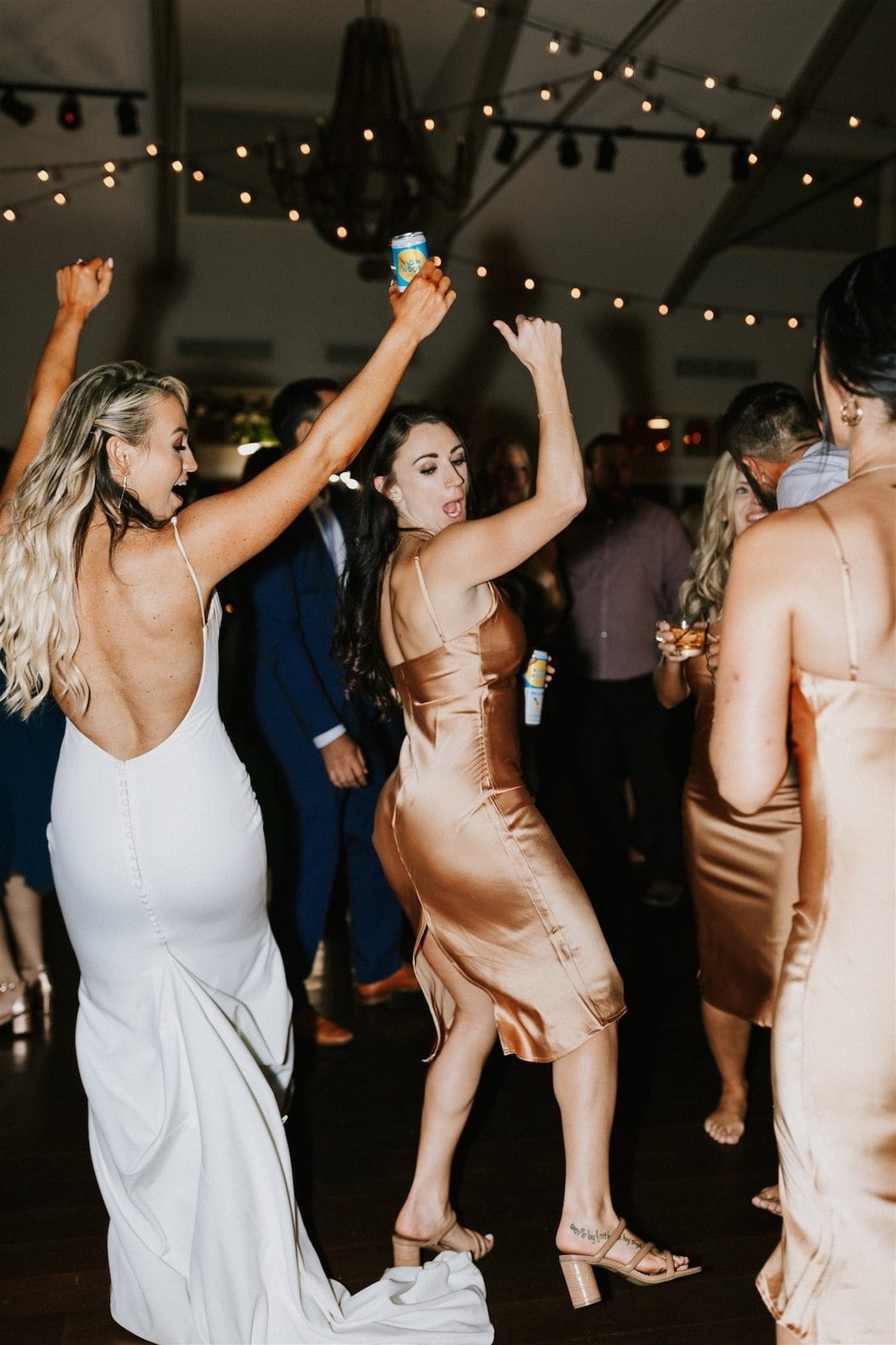 bride and bridesmaid dancing with hands up