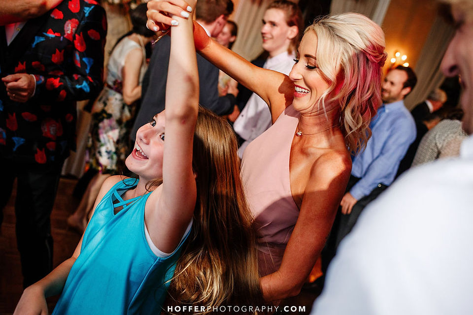 woman spins young girl dancing at wedding