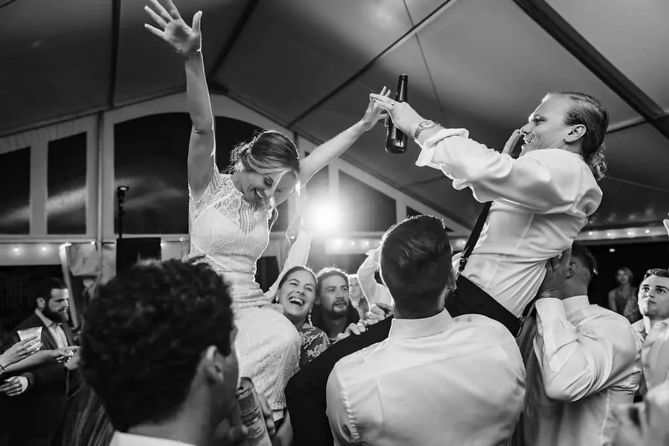 bride and groom in chairs for hora at wedding