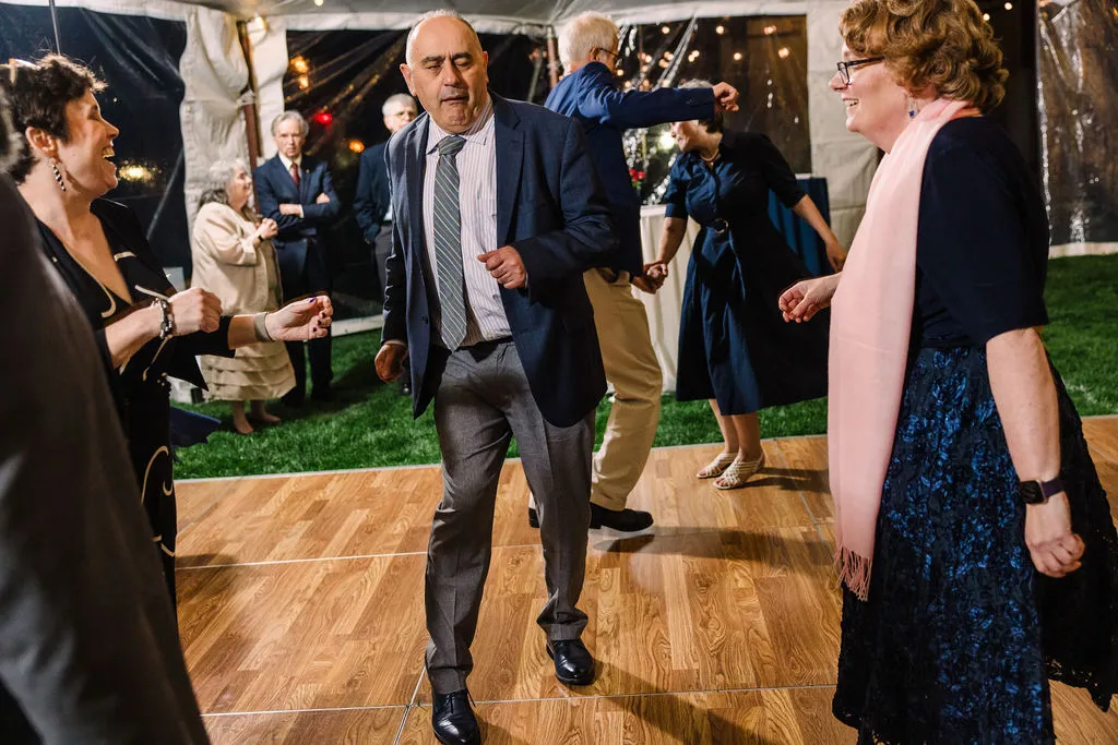 guests dancing at wedding in a tent