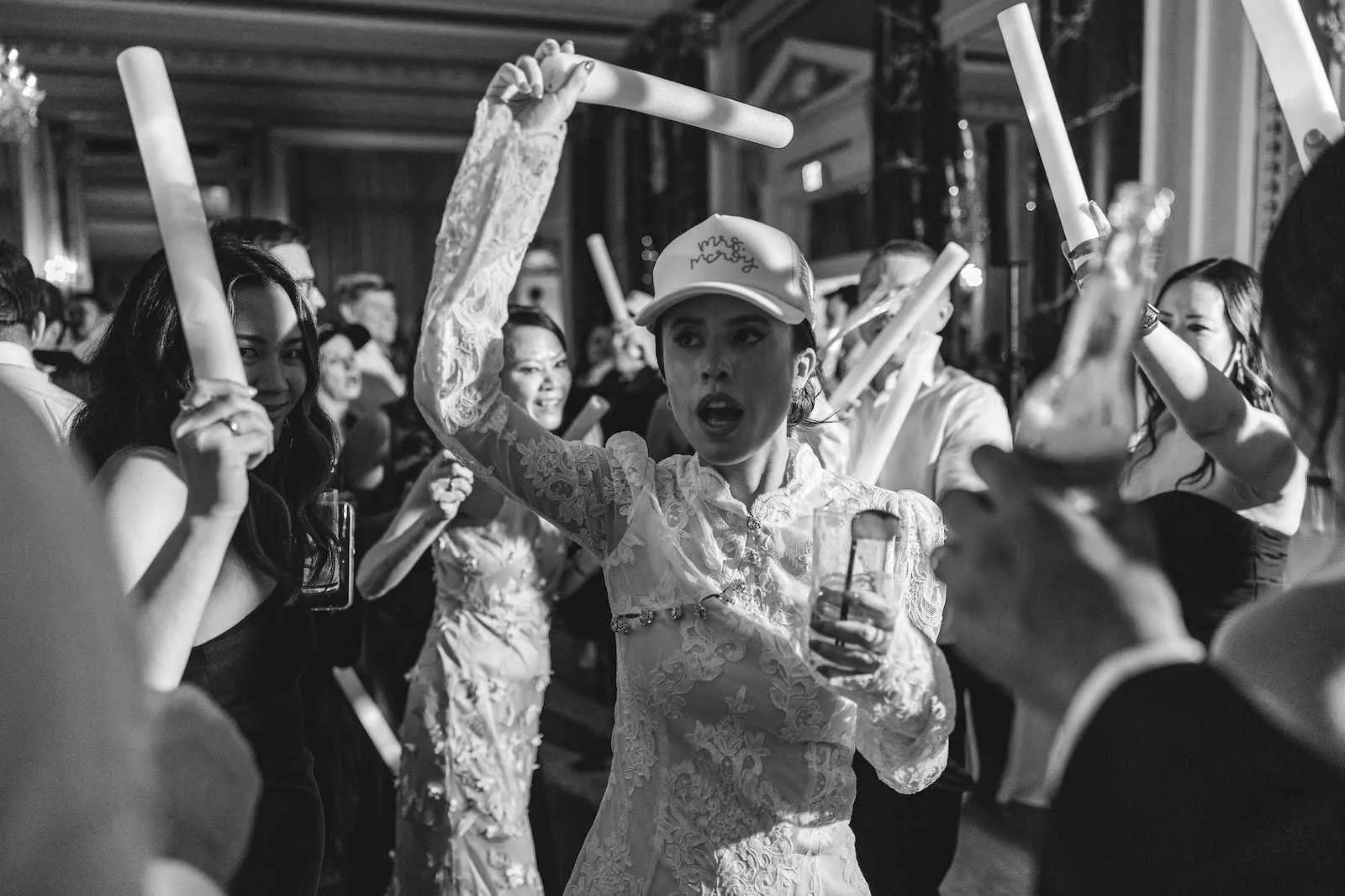bride in trucker hat dancing with guests