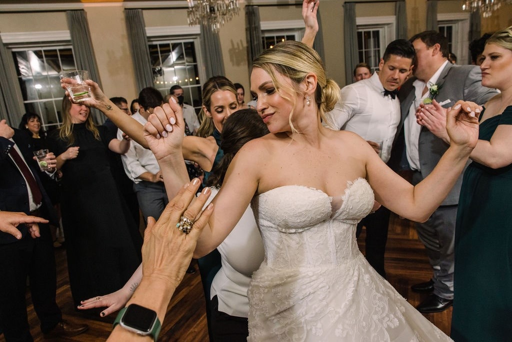 bride dancing with women at wedding